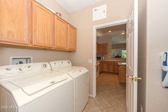 laundry area with cabinets, light tile patterned flooring, and separate washer and dryer