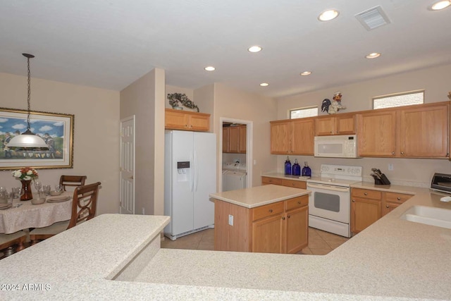 kitchen featuring white appliances, washer and dryer, light tile patterned flooring, a kitchen island, and decorative light fixtures