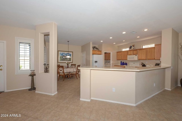 kitchen with white appliances, pendant lighting, light tile patterned flooring, and kitchen peninsula