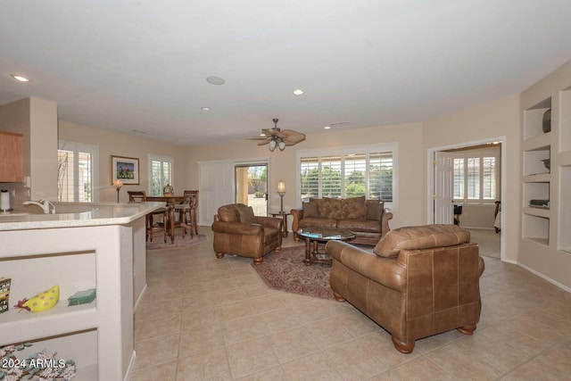 tiled living room featuring sink, built in features, and ceiling fan