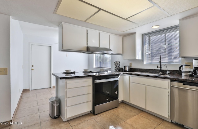 kitchen featuring a peninsula, stainless steel appliances, under cabinet range hood, a sink, and light tile patterned flooring