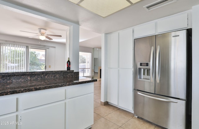 kitchen featuring light tile patterned floors, visible vents, white cabinets, dark stone countertops, and stainless steel fridge with ice dispenser