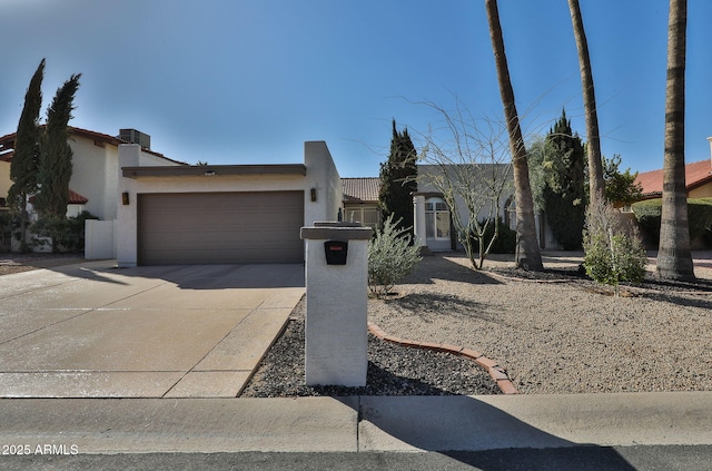 view of front of home featuring a garage, driveway, and stucco siding