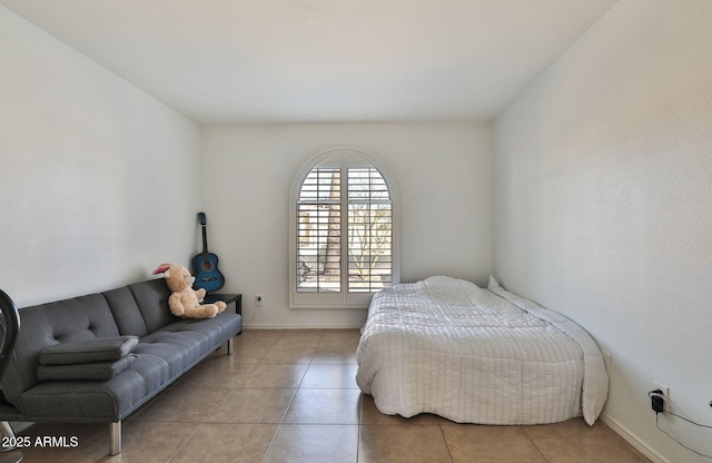 bedroom with light tile patterned floors and baseboards