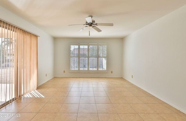 spare room featuring ceiling fan, baseboards, a wealth of natural light, and light tile patterned flooring