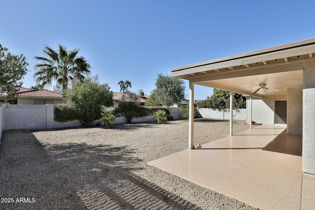 view of yard featuring a patio area, ceiling fan, and a fenced backyard