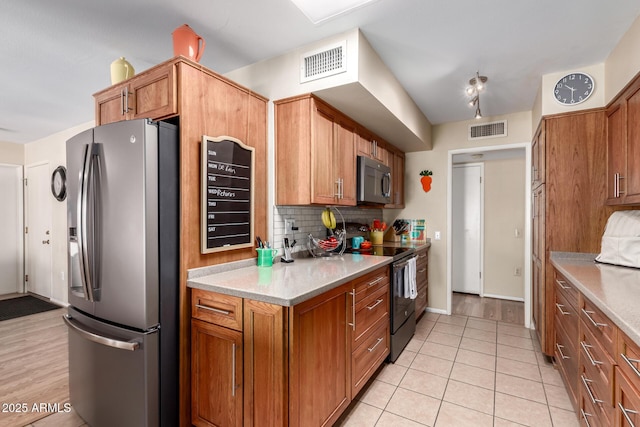 kitchen featuring tasteful backsplash, light tile patterned floors, and appliances with stainless steel finishes