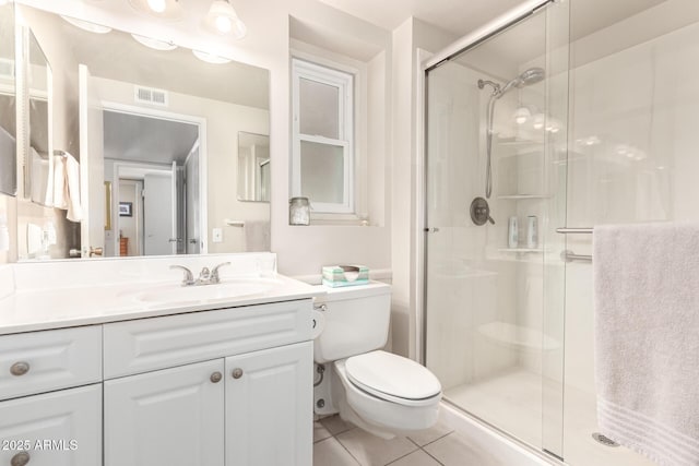 bathroom with a shower with door, vanity, tile patterned floors, and toilet