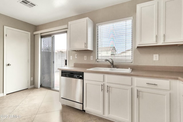 kitchen featuring plenty of natural light, sink, stainless steel dishwasher, and white cabinets