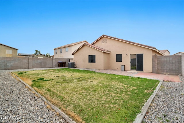 back of house with a lawn, central air condition unit, and a patio area