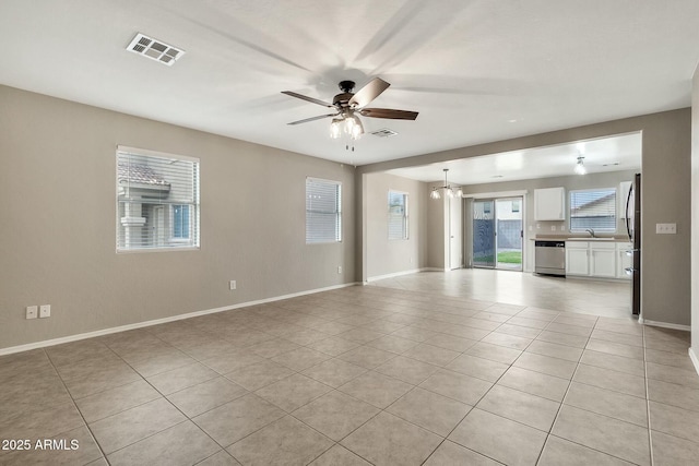 tiled spare room featuring ceiling fan with notable chandelier