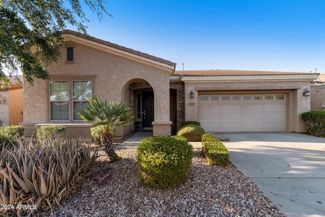 view of front of home with concrete driveway, a garage, and stucco siding