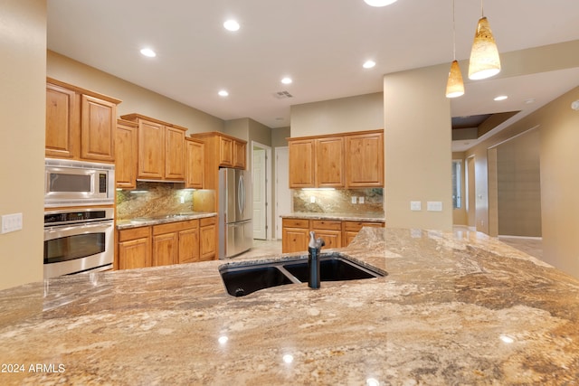 kitchen featuring light stone countertops, visible vents, recessed lighting, a sink, and stainless steel appliances