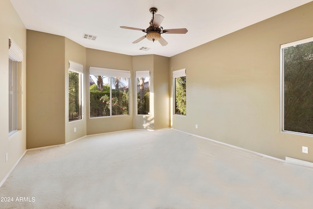 empty room with visible vents, a healthy amount of sunlight, and ceiling fan