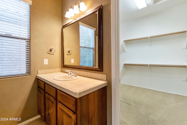 bathroom featuring a spacious closet and vanity