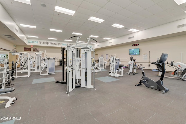 exercise room with a paneled ceiling and visible vents