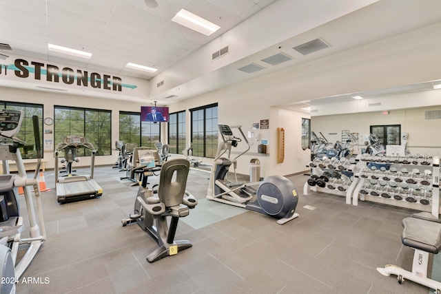 gym featuring a paneled ceiling, visible vents, and a towering ceiling