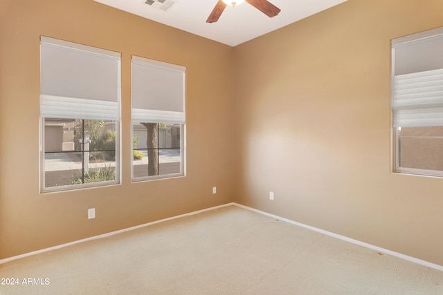 spare room featuring visible vents, baseboards, ceiling fan, and carpet flooring