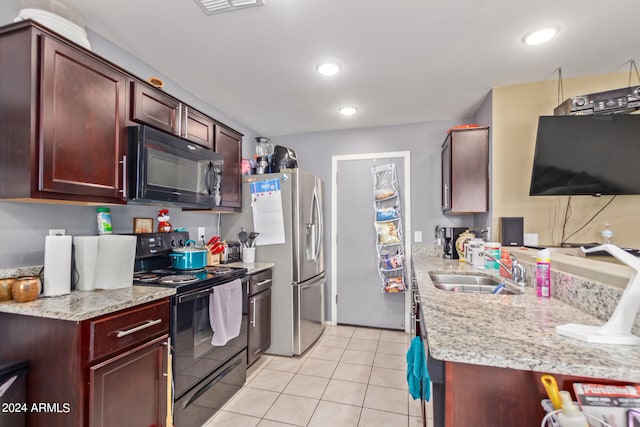 kitchen featuring light tile patterned floors, black appliances, light stone counters, and sink