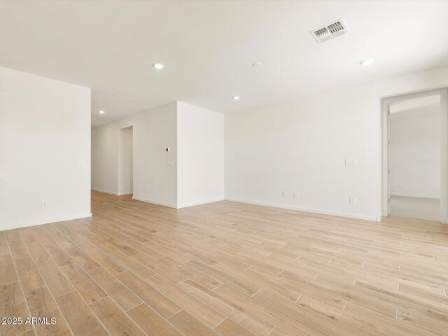 unfurnished room featuring recessed lighting, visible vents, light wood-type flooring, and baseboards
