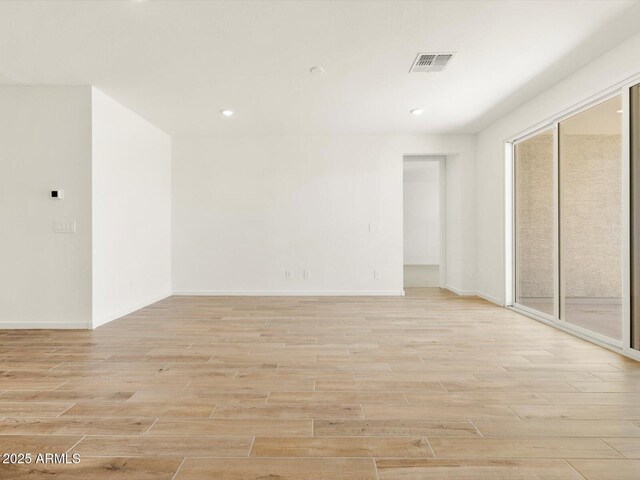 spare room with light wood-style floors, recessed lighting, visible vents, and baseboards