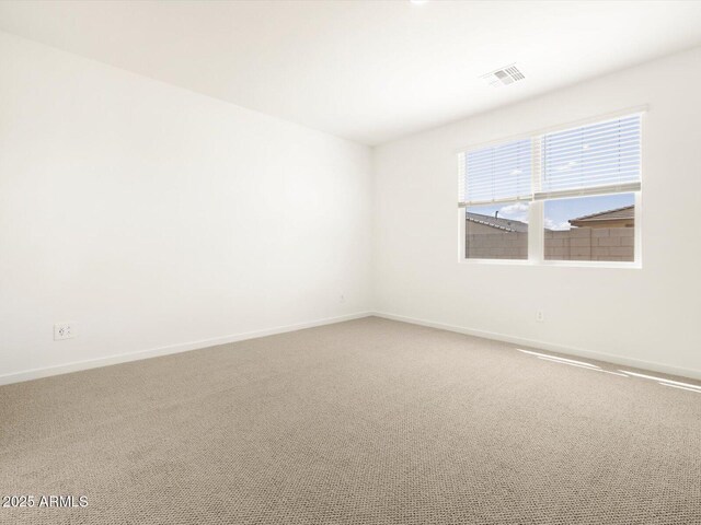 carpeted empty room with visible vents and baseboards