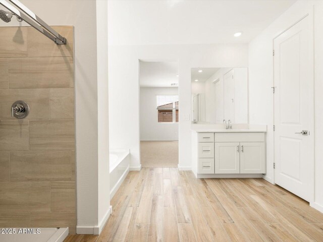 full bath with vanity, baseboards, a tile shower, a garden tub, and wood finished floors