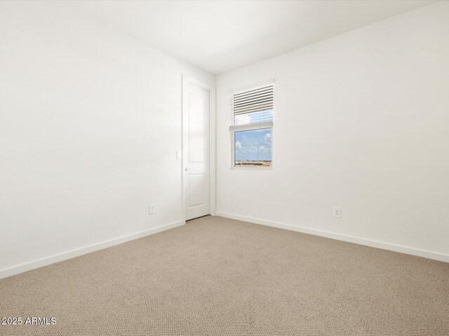 empty room with baseboards and light colored carpet