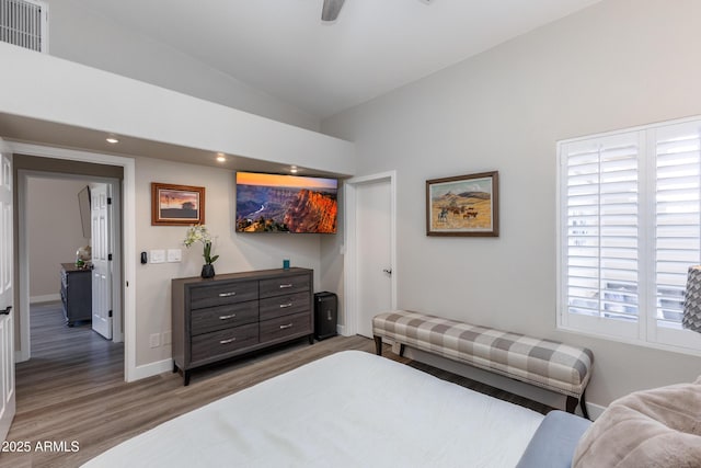 bedroom featuring visible vents, wood finished floors, recessed lighting, baseboards, and lofted ceiling