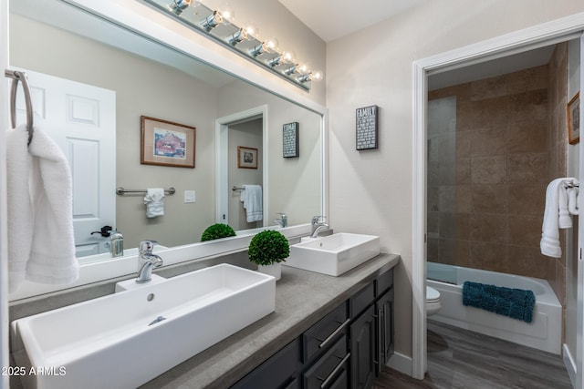 bathroom featuring  shower combination, toilet, wood finished floors, and a sink