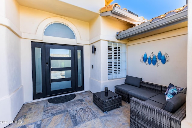 property entrance with an outdoor living space and stucco siding