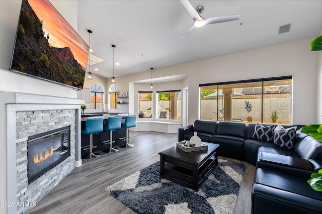 living room with wood finished floors, visible vents, a fireplace, recessed lighting, and ceiling fan