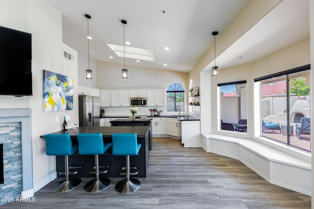 kitchen with a peninsula, a wealth of natural light, appliances with stainless steel finishes, and a sink