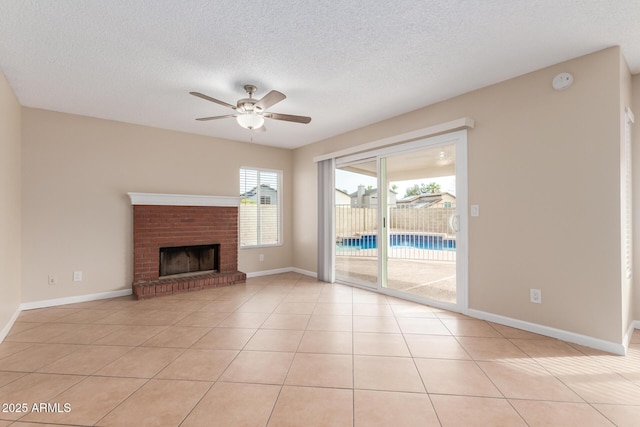 unfurnished living room with light tile patterned floors, a fireplace, a textured ceiling, and a ceiling fan