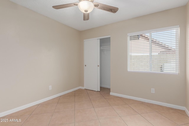 unfurnished bedroom with a closet, baseboards, and light tile patterned flooring