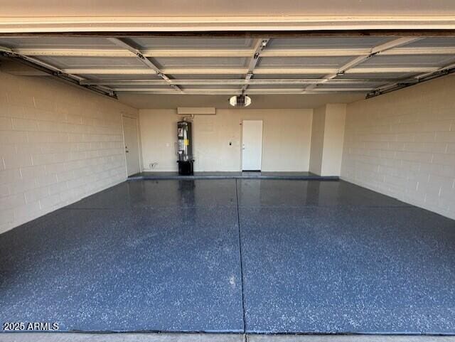 garage featuring concrete block wall and water heater