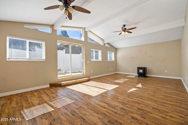 unfurnished living room featuring ceiling fan, lofted ceiling with beams, hardwood / wood-style floors, and a wood stove