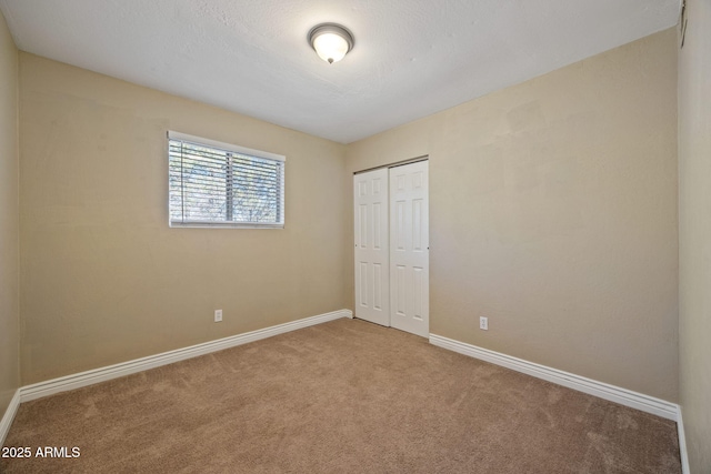 unfurnished bedroom with carpet flooring, a textured ceiling, and a closet