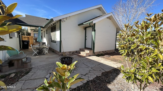 rear view of property with a patio and an outdoor fire pit