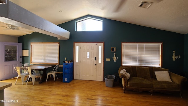 entryway featuring a textured ceiling, light hardwood / wood-style flooring, ceiling fan, and vaulted ceiling