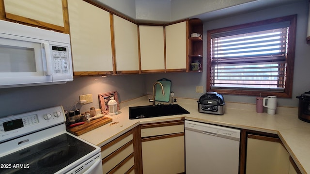 kitchen featuring white cabinetry, sink, and white appliances