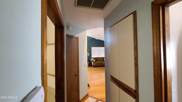 corridor featuring vaulted ceiling and light hardwood / wood-style floors