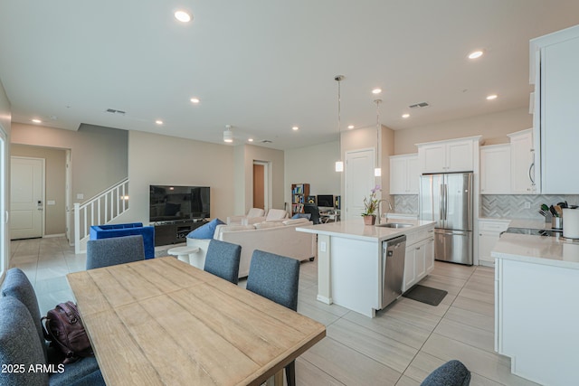 281 E Shamrock Dr, Chandler, AZ 85286 - kitchen with stainless steel appliances, open floor plan, decorative backsplash, light countertops, and an island with sink