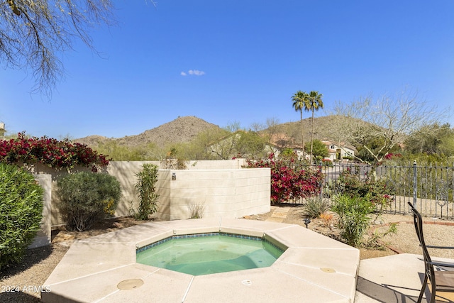 view of pool featuring a mountain view and an in ground hot tub