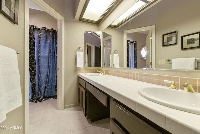 bathroom featuring vanity, tile patterned floors, backsplash, and vaulted ceiling