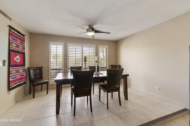 tiled dining room featuring ceiling fan and a textured ceiling