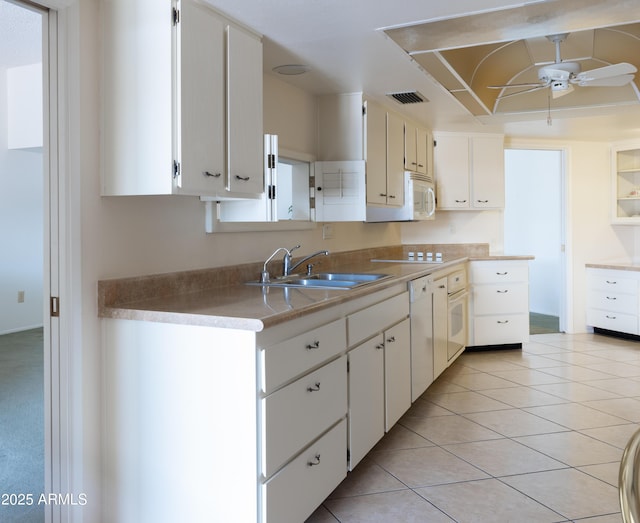 kitchen with white appliances, visible vents, ceiling fan, a sink, and light tile patterned flooring