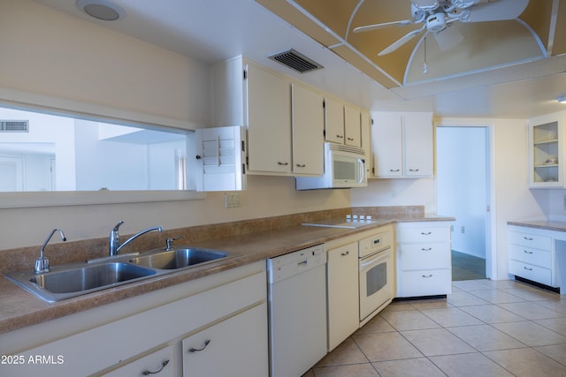 kitchen featuring white appliances, visible vents, a sink, and light tile patterned floors