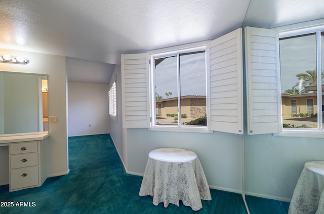 interior space with a textured ceiling and baseboards