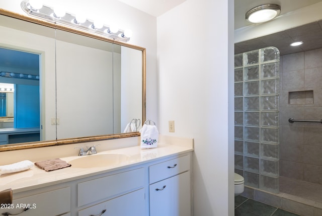 full bath with toilet, tile patterned flooring, a walk in shower, and vanity